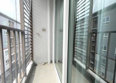 Narrow high-rise apartment balcony with large glass windows