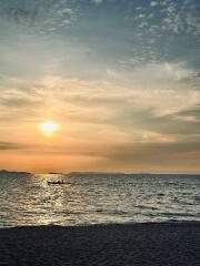 Serene beach sunset with boat on the water