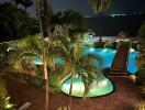 Luxurious poolside with tropical landscaping at night