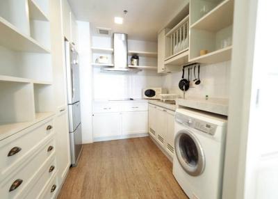 Compact modern kitchen with white appliances and wooden flooring