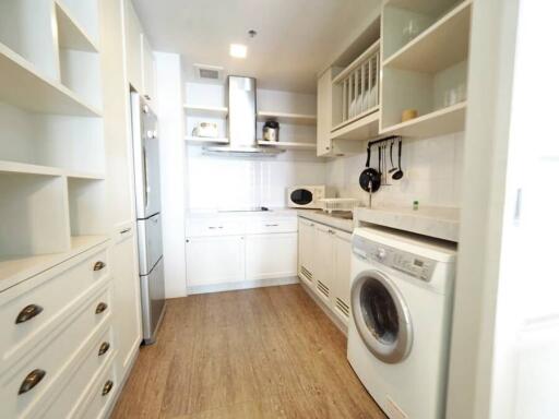 Compact modern kitchen with white appliances and wooden flooring