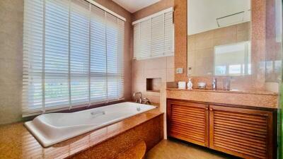 Spacious bathroom with large bathtub, modern fixtures, and natural light