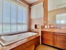 Spacious bathroom with large bathtub, modern fixtures, and natural light