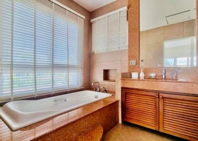 Spacious bathroom with large bathtub, modern fixtures, and natural light