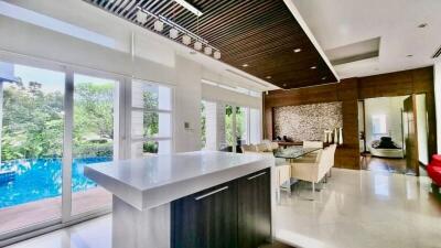 Modern kitchen with open plan dining area overlooking a pool