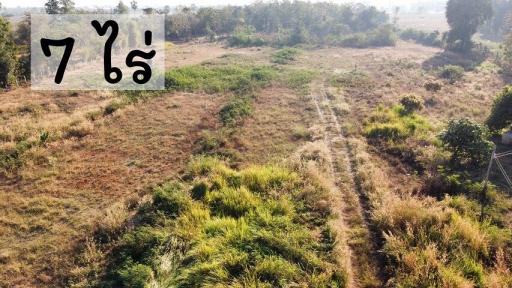 Aerial view of a vacant land with sparse vegetation and a dirt path