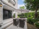 Cozy patio area with dining set and lush greenery