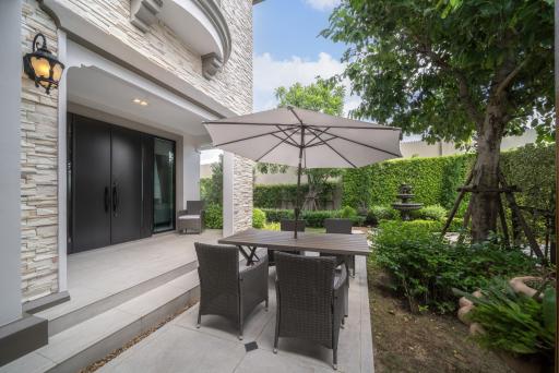 Cozy patio area with dining set and lush greenery