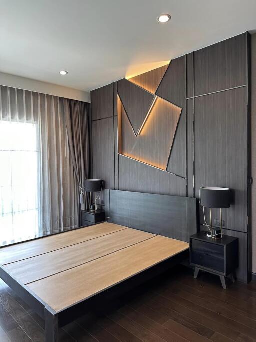 Contemporary bedroom with elegant wooden bed and artistic wall panel lighting