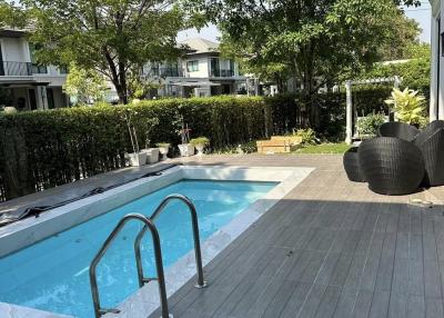 Swimming pool area with wooden deck and outdoor furniture in a residential property