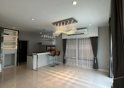 Modern living space with open kitchen design, elegant lighting, and ample natural light