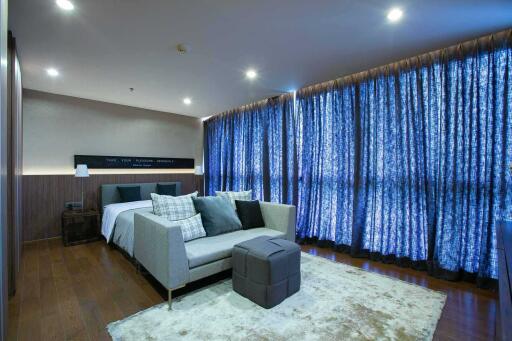 Modern bedroom interior with king-size bed and comfortable sitting area