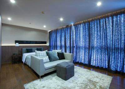 Modern bedroom interior with king-size bed and comfortable sitting area