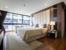Modern bedroom with a large bed, floor-to-ceiling windows, and wooden accents