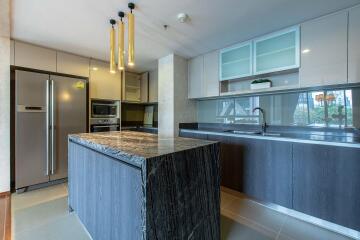 Modern kitchen with marble island, stainless steel appliances, and ample cabinetry
