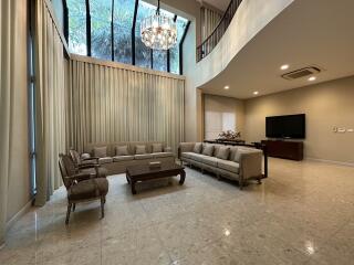 Spacious and modern living room with high ceiling and large window