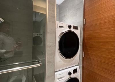 Modern bathroom with stacked washer and dryer and sleek finishes