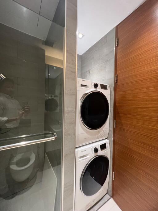 Modern bathroom with stacked washer and dryer and sleek finishes