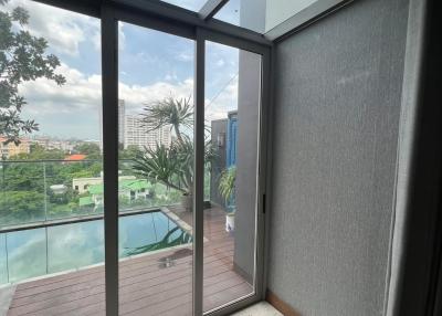 Balcony with glass doors and view of the pool and cityscape