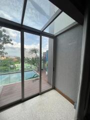 Balcony with glass doors and view of the pool and cityscape