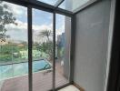 Balcony with glass doors and view of the pool and cityscape