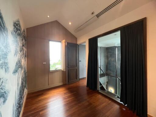 Spacious bedroom with wooden flooring and balcony access