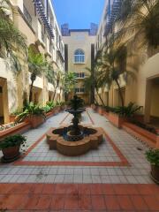 Elegant courtyard in residential building with central fountain and palm trees