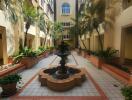 Elegant courtyard in residential building with central fountain and palm trees