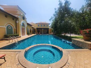 Luxurious outdoor pool area with a spa and sun loungers