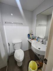 Compact bathroom with white fixtures and tiled walls