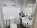Compact bathroom with white fixtures and tiled walls