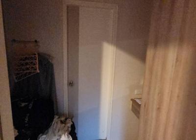 Dimly lit hallway with closed door and laundry items