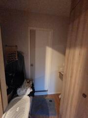 Dimly lit hallway with closed door and laundry items