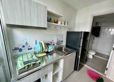 Small apartment kitchen with open cabinetry and adjacent bathroom