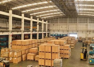 Spacious warehouse interior with stacked boxes and industrial lighting