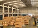 Spacious warehouse interior with stacked boxes and industrial lighting