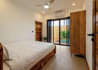 Bright and spacious bedroom with large bed and sliding door to outdoor area
