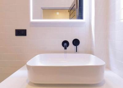 Modern bathroom sink with elegant fixtures and tiled wall