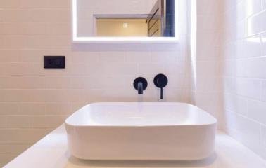 Modern bathroom sink with elegant fixtures and tiled wall