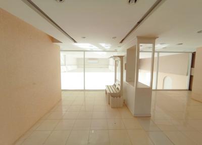Spacious open plan interior of a bright building with large windows and tiled flooring
