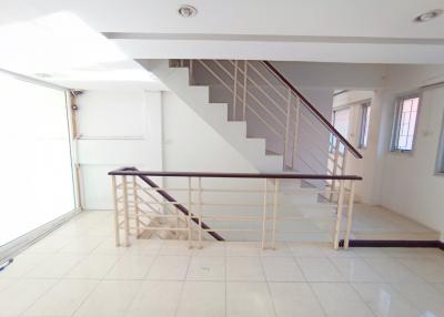 Spacious living room with staircase and tile flooring