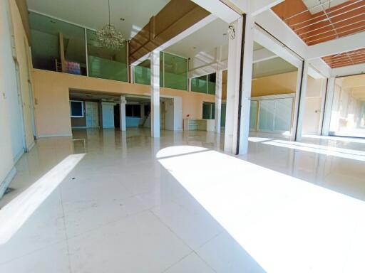 Spacious and well-lit empty commercial space with large windows and reflective flooring