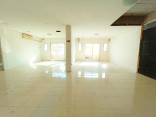 Bright spacious empty interior of a building with large windows and tiled flooring