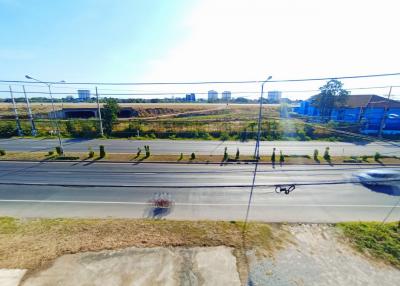 Wide-angle view of a property adjacent to a road with clear blue sky