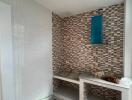 Unfinished bathroom interior with mosaic wall tiles and construction materials