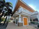 Spacious two-story house with a balcony and paved front yard