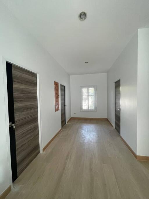 Empty bedroom with wooden flooring and white walls