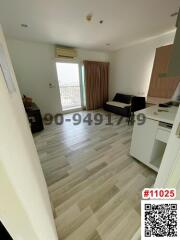 Compact living room with kitchenette and balcony access