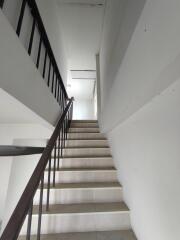 Interior image of a stairwell with white walls and tiled steps