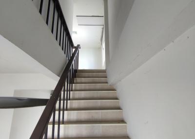 Interior image of a stairwell with white walls and tiled steps